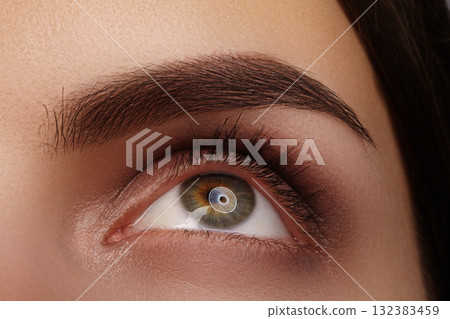 Macro close-up hazel eye and defined eyebrow, natural makeup and clean beauty expression. Macro for cosmetic brand or ophthalmology clinic, permanent make-up, laser vision correction Macro close-up hazel eye and defined eyebrow, natural makeup and clean beauty expression. Macro for cosmetic brand or ophthalmology clinic, permanent make-up, laser vision correction 132383459