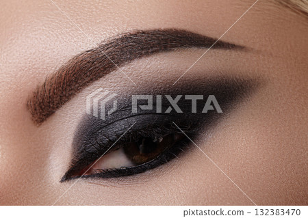 Smoky eye makeup with deep black shadows and blended crease. Texture and intense pigment for editorial fashion and beauty campaigns. Smokey make-up for witch or black cat Halloween style Smoky eye makeup with deep black shadows and blended crease. Texture and intense pigment for editorial fashion and beauty campaigns. Smokey make-up for witch or black cat Halloween style 132383470