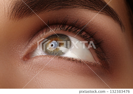 Close-up macro of a womans eye looking upward, soft lighting catching iris detail and lashes. Emphasizes upward gaze and emotion, suitable for beauty, ophthalmological clinic and cosmetic Close-up macro of a womans eye looking upward, soft lighting catching iris detail and lashes. Emphasizes upward gaze and emotion, suitable for beauty, ophthalmological clinic and cosmetic 132383476