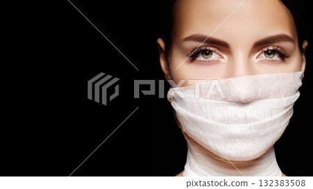 Beautiful woman with bandage mask on face. Fashion eye make-up. Beauty surgery or protection hygiene in virus pandemic Beautiful woman with bandage mask on face. Fashion eye make-up. Beauty surgery or protection hygiene in virus pandemic 132383508