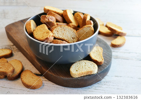 Crispy rusks in bowl on wooden table, closeup Crispy rusks in bowl on wooden table, closeup 132383616