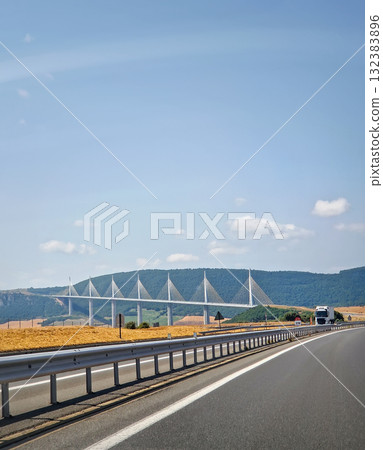 The Millau Viaduct soaring across the Tarn valley in Southern France. A monumental engineering marvel, cable-stayed bridge supported by tall, tapered piers and masts, giving it a yacht-like appearance The Millau Viaduct soaring across the Tarn valley in Southern France. A monumental engineering marvel, cable-stayed bridge supported by tall, tapered piers and masts, giving it a yacht-like appearance 132383896