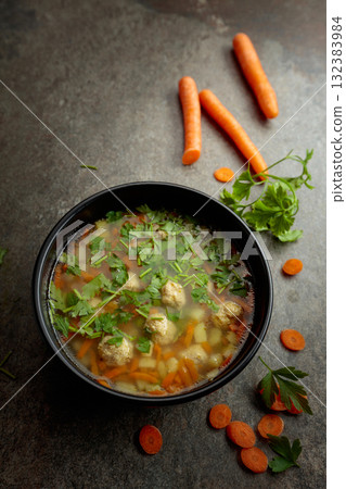 Classic meatball soup with potatoes,  carrot and greens. 132383984