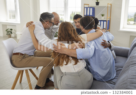 Team of diverse business people and friends sitting in circle and hugging each other 132384001