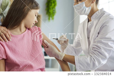 Nurse giving vaccination injection to child at clinic, pediatric safety care Nurse giving vaccination injection to child at clinic, pediatric safety care 132384014