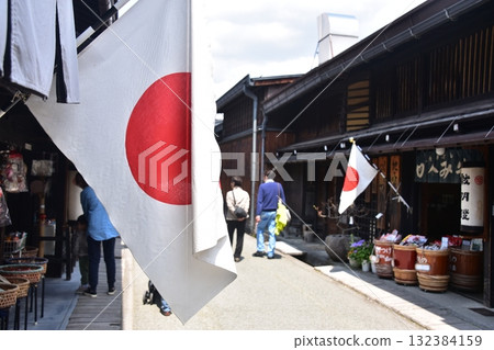 Old streetscape of Takayama city, Gifu prefecture, Japan. Stores displaying Japanese flags and tourists enjoying shopping during the Spring Takayama Festival. 132384159