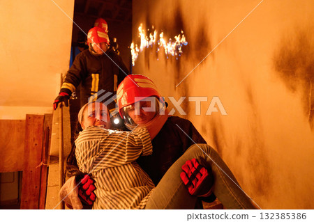 Courageous firefighter carrying a rescued woman down a burning staircase during an emergency evacuation, symbolizing bravery, heroism, and dedication to saving lives in dangerous situations. Courageous firefighter carrying a rescued woman down a burning staircase during an emergency evacuation, symbolizing bravery, heroism, and dedication to saving lives in dangerous situations. 132385386