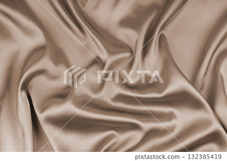 Crumpled, wrinkled beige colored glossy silk satin texture. Shiny smooth fabric with soft folds Crumpled, wrinkled beige colored glossy silk satin texture. Shiny smooth fabric with soft folds 132385419