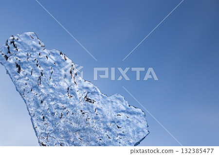 Ice shards and blue sky background Ice shards and blue sky background 132385477