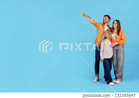 Family pointing aside at copy space while standing together on blue background 132385647