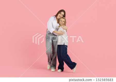 Happy young Caucasian family, mom and daughter posing in bright studio Happy young Caucasian family, mom and daughter posing in bright studio 132385683