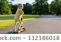 Scooter and kid. Toddler outdoor riding. Fun yellow play childhood freedom. 132386018