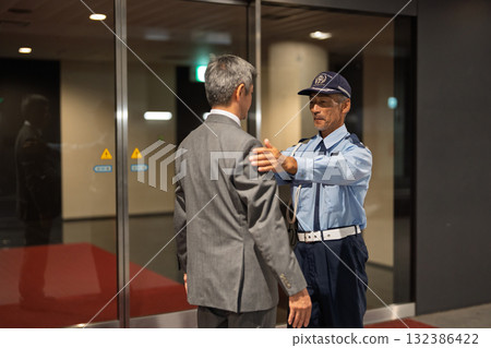 Security guard body check senior man Security guard body check senior man 132386422