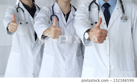 Doctor team showing thumbs up, symbolizing healthcare success, medical approval, achieving goals, quality patient care, positive health outcomes, and professional support 132386599