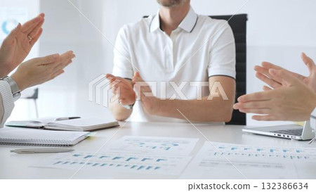 Professional business people team clapping hands, celebrating successful presentation, displaying collaborative spirit in modern office Professional business people team clapping hands, celebrating successful presentation, displaying collaborative spirit in modern office 132386634