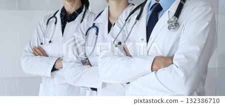 A group of doctors with folded arms demonstrates the professionalism of medicine, mutual support of clinics, and dedication to expert care in a hospital setting 132386710