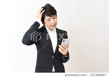 A middle-aged Asian woman having trouble operating her smartphone 132386867