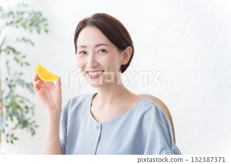 Woman eating orange fruit 132387371