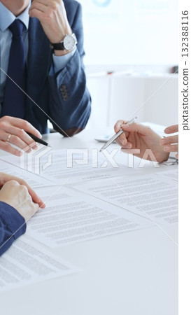 Business colleagues reviewing contract documents during an office meeting, discussing terms, and preparing for agreement signing, focusing on legal consultation and partnership discussion Business colleagues reviewing contract documents during an office meeting, discussing terms, and preparing for agreement signing, focusing on legal consultation and partnership discussion 132388116
