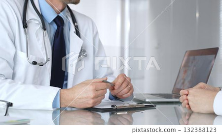 Doctor consulting patient about healthcare, discussing medical examination results on laptop in clinic office. Medicine, healthcare and science concept Doctor consulting patient about healthcare, discussing medical examination results on laptop in clinic office. Medicine, healthcare and science concept 132388123