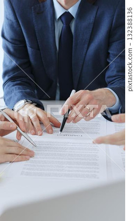 Businesspeople hands with pens reviewing documents and engaging in a discussion across a table, representing contract signing, legal consultation, negotiation, and important agreement collaboration Businesspeople hands with pens reviewing documents and engaging in a discussion across a table, representing contract signing, legal consultation, negotiation, and important agreement collaboration 132388136
