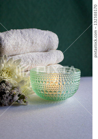 Vertical real shot of delicate spa composition ,with towels, flowers and candlelight. Vertical real shot of delicate spa composition ,with towels, flowers and candlelight. 132388170