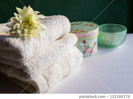 Relaxing spa scene with towels, candles and sunlight through window. Horizontal shot 132388178