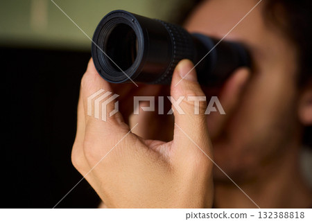 A Person Diligently Using a Telescope for Detailed Observation of the Night Sky and Beyond 132388818