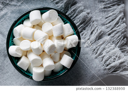 White Marshmallow Candies in Bowl on Gray Fabric Top View Copy Space 132388930