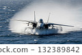Military Jet Aircraft Touching Down On Water Surface Generating Significant Water Spray 132389842
