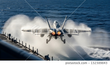 Military Jet Departing Aircraft Carrier on Blue Ocean Generating Vapor and Flames Military Jet Departing Aircraft Carrier on Blue Ocean Generating Vapor and Flames 132389843