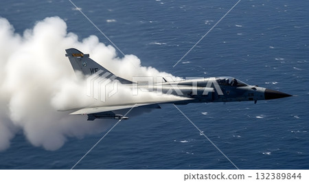 A Gray Fighter Jet Generating Vapor Trail Over Blue Ocean Depicting Speed and Power A Gray Fighter Jet Generating Vapor Trail Over Blue Ocean Depicting Speed and Power 132389844