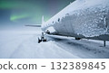 Abandoned Airplane Frozen in Snow Under Green Aurora Borealis Display in a Winter Landscape 132389845