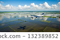 Aerial View Of Airplane Flying Above Flooded Agricultural Fields Reflecting Sky And Clouds 132389852
