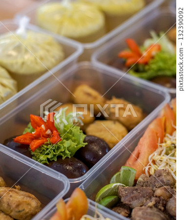 Packed meal boxes containing marinated glossy eggs, fried snacks, vermicelli noodles, bean sprouts, tomato and lime slices, ideal for catering, meal prep services, menus and food delivery marketing 132390092