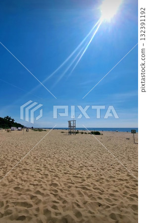 A simple, elevated white wooden structure used by lifeguards stands on the sand overlooking the Baltic Sea. 132391192