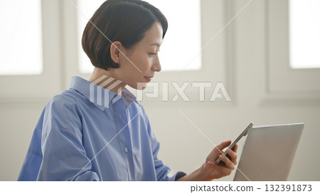 A woman using a computer (mobile phone operation) 132391873
