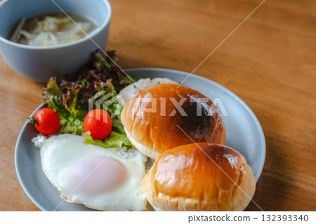 Western-style breakfast with rolls, fried eggs, salad and soup 132393340