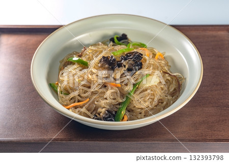 korean food japchae, Stir-fried Glass Noodles andVegetables, Glass noodles stir-fried with beef and assorted mushrooms and vegetables. A colorful classic dish that is always served at large gatherings korean food japchae, Stir-fried Glass Noodles andVegetables, Glass noodles stir-fried with beef and assorted mushrooms and vegetables. A colorful classic dish that is always served at large gatherings 132393798