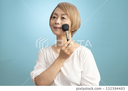 Senior woman putting on makeup 132394483