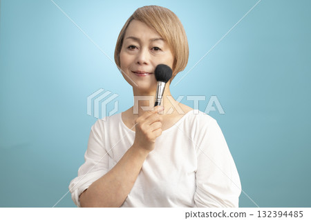 Senior woman putting on makeup 132394485