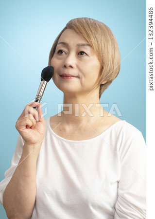 Senior woman putting on makeup 132394486