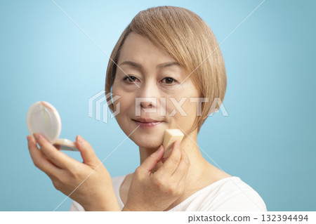 Senior woman putting on makeup 132394494