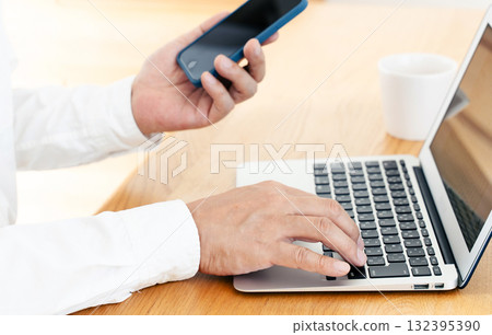 Hand of a man manipulating a smartphone Hand of a man manipulating a smartphone 132395390