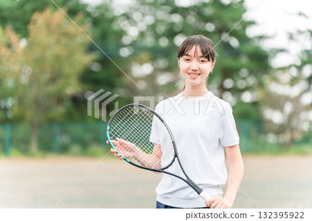 小學、國中和高中女生穿著運動服，在校園或操場上手持網球拍 132395922