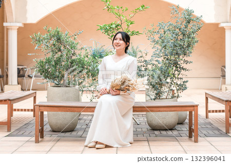 Woman in wedding dress on courtyard, patio, bride Woman in wedding dress on courtyard, patio, bride 132396041