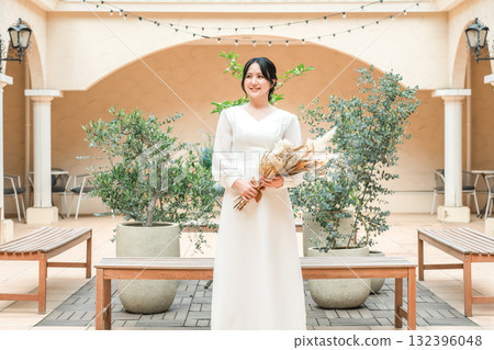 Woman in wedding dress on courtyard, patio, bride Woman in wedding dress on courtyard, patio, bride 132396048