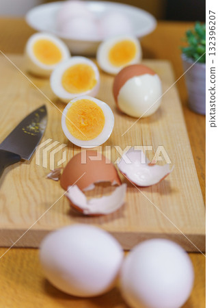 Cut the boiled eggs in half with a knife 132396207