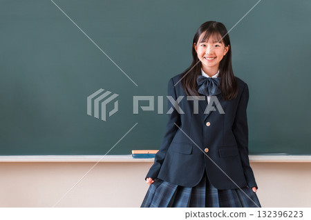 Female students in uniforms, elementary school, junior high school, and high school standing in front of the blackboard in the classroom 132396223