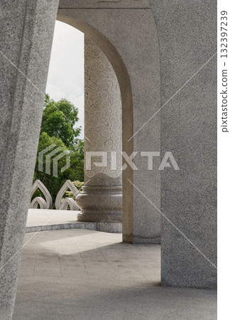 a view through a series of arches and stone pillars, The sunlight casts shadows on the architectural elements, which highlights their texture and form. 132397239